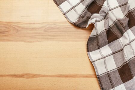 Top view on a wooden table with a linen kitchen towel or textile napkin. a tablecloth on a...