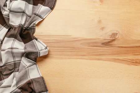 Top view on a wooden table with a linen kitchen towel or textile napkin. a tablecloth on a...