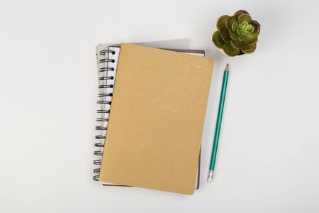 a stack of several spiral school notebooks lies on a white table with a pencil, office concept