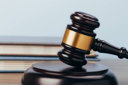 Judge Gavel with books on a wooden table and a blue background. The concept of law. sentence, justiceの写真素材