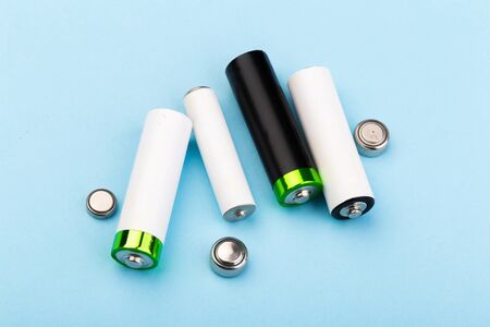 many new and used AA batteries on a blue background.の写真素材