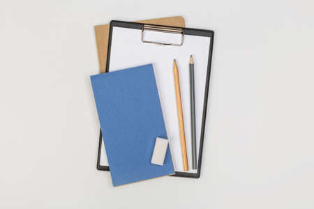 a stack of several spiral school notebooks lies on a white table with a pencil, office conceptの写真素材