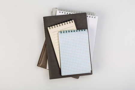 a stack of several spiral school notebooks lies on a white table with a pencil, office conceptの写真素材