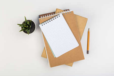 a stack of several spiral school notebooks lies on a white table with a pencil, office conceptの写真素材