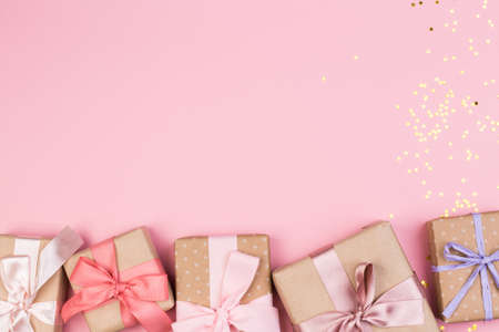 Gift or gift box and stars confetti on a pink table from above. Flat composition for birthday,...