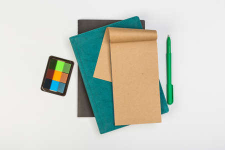 a stack of several spiral school notebooks lies on a white table with a pencil, office conceptの写真素材