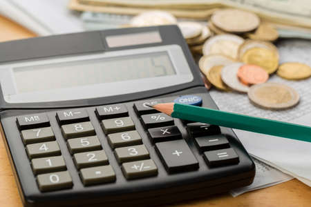 Coin money and banknote bills with a calculator. savings, finance, economics