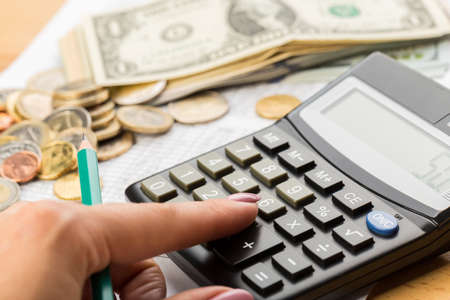 Coin money and banknote bills with a calculator. savings, finance, economics