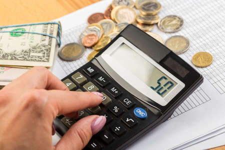 Coin money and banknote bills with a calculator. savings, finance, economicsの写真素材