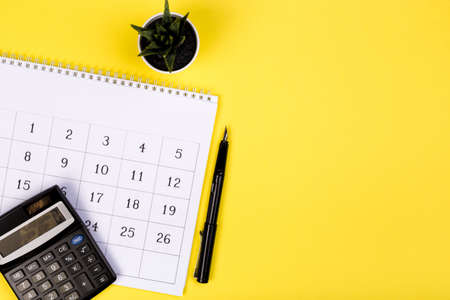 White clean calendar on solid yellow background with copy space, business meeting schedule, travel planning or project milestone and reminder concept.の写真素材