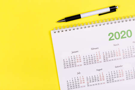 White clean calendar on solid yellow background with copy space, business meeting schedule, travel planning or project milestone and reminder concept.の写真素材