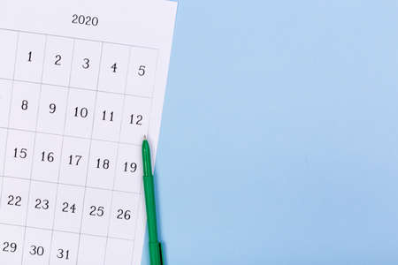 close up top view on white calendar 2020 month schedule to make appointment meeting or manage timetable each day lay on blue background for planning work and life conceptの写真素材
