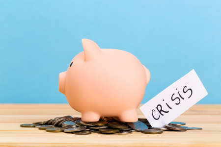Pink piggy bank on wooden table and blue background. The concept of storage, accumulation. Crisis,...