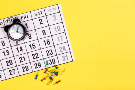 White clean calendar on solid yellow background with copy space, business meeting schedule, travel planning or project milestone and reminder concept.の写真素材