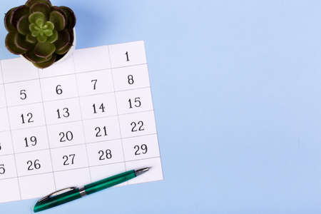 close up top view on white calendar 2020 month schedule to make appointment meeting or manage timetable each day lay on blue background for planning work and life conceptの写真素材