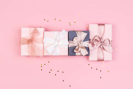 Gift or gift box and stars confetti on a pink table from above. Flat composition for birthday, mothers day or wedding.の写真素材