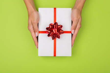 Hands holding crafts paper gift box with a gift for Christmas, New Year, Valentine's Day or...