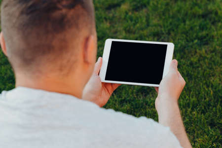 male hands holding an electronic tablet mock-up for your text message or information content,...