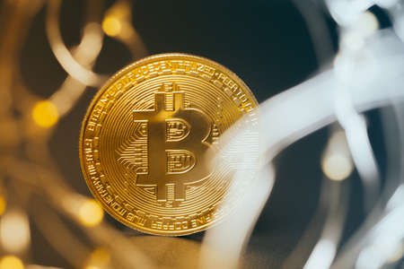 Golden bitcoin with yellow bokeh background. Cryptocurrency concept.の写真素材