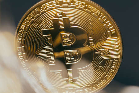Golden bitcoin with yellow bokeh background. Cryptocurrency concept.の写真素材