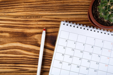 white calendar for month schedule to make an appointment or manage the schedule every day on a wooden table with succulent and ballpoint pen for marks, for work planningの写真素材