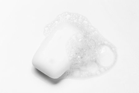 Soap bar and foam on white background
