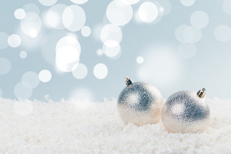 classic silver Christmas balls in the snow on a blue background with bokeh lights. happy new year cardの写真素材
