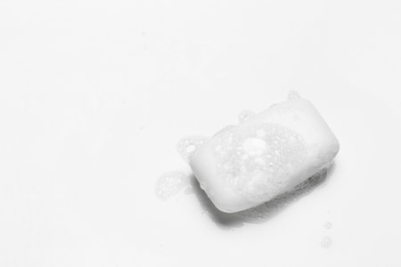 Soap bar and foam on white background