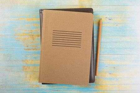 school colored notepads with ballpoint pen on blue wooden background