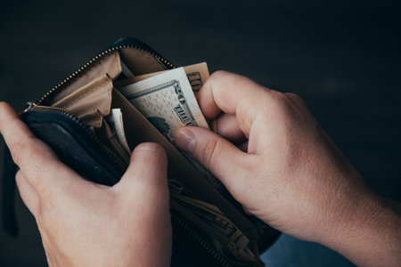 man shows wallet with a bundle of dollar bills, there is little money in the wallet, financial...