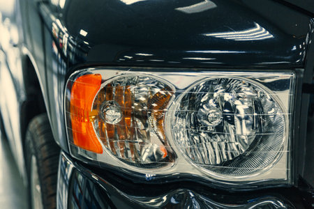 headlights of a retro black car in a showroom. close-up