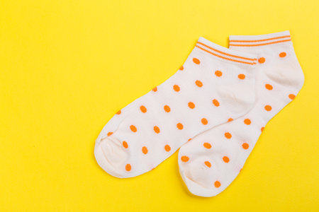 colored socks from fine knitwear on a yellow background. Clothing in the form of socks.