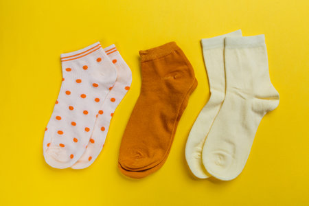 Multi-colored socks on a yellow background. View from above. Many different socks for cold seasonsの写真素材