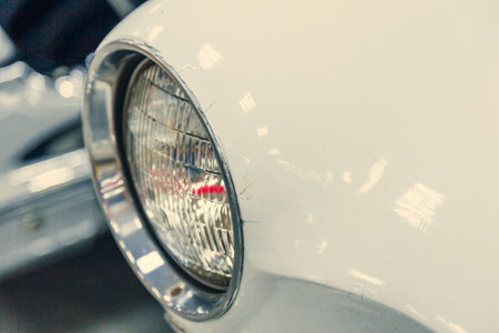 close-up of headlight of white retro car. off, car in garage