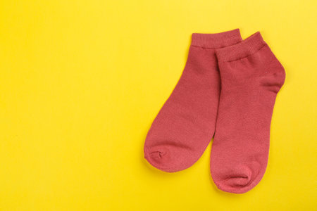 colored socks from fine knitwear on a yellow background. Clothing in the form of socks.