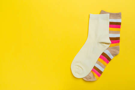 Multi-colored socks on a yellow background. View from above. Many different socks for cold seasonsの写真素材