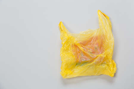 used yellow plastic disposable bag on gray background