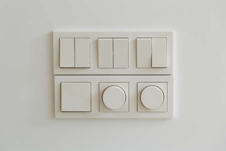 light switch, white plastic mechanical switch mounted on a gray wall.の写真素材