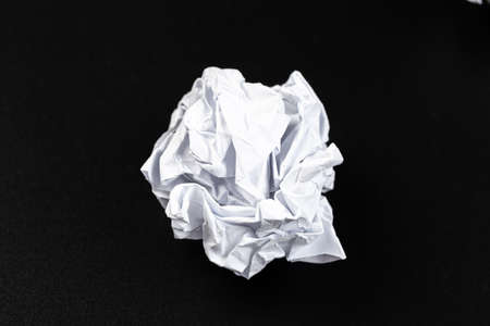A piece of crumpled white paper on a black background.の写真素材