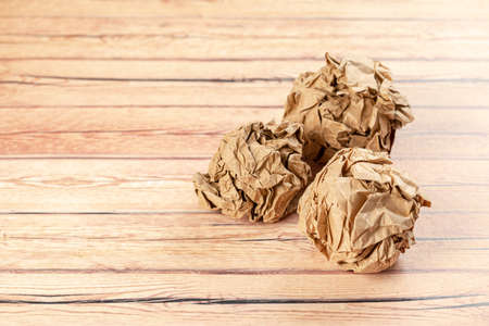 many balls of crumpled paper on a wooden table. search for inspiration, ideas. search difficultiesの写真素材