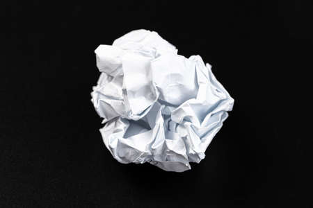 A piece of crumpled white paper on a black background.の写真素材