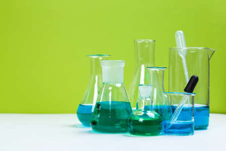 Laboratory glassware with solutions of different colors on tableの写真素材