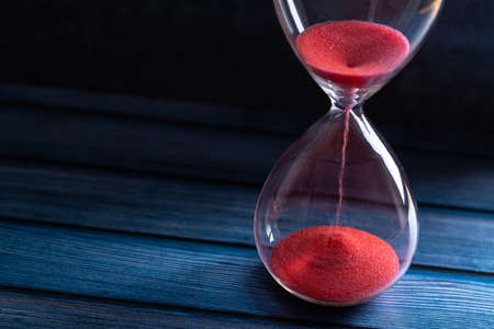 Hourglass as a concept of passing time for business deadline, urgency and outcome of time.の写真素材