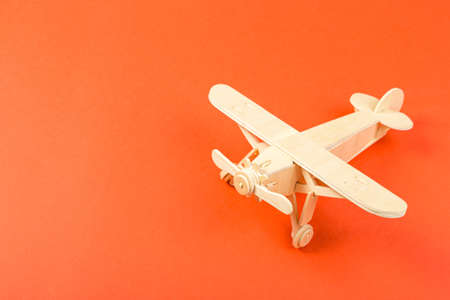 wooden model of a passenger plane with on an orange background.の写真素材
