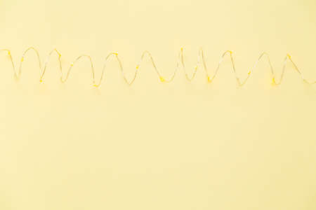 The garland is on. Glowing electric garland on a yellow background. top viewの写真素材