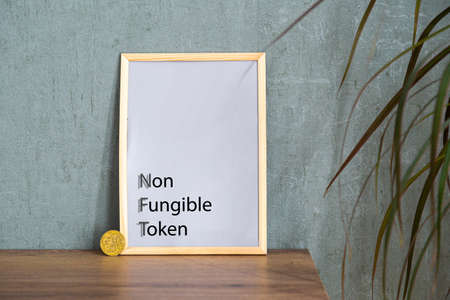 NFT non - fungible tokens inscription in the art frame. A non-fungible token (NFT) is a special type of cryptographic token which represents something unique.の写真素材