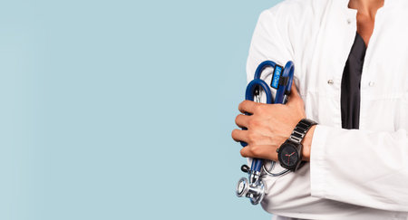 Handsome modern Indian / Asian doctor with stethoscope, in uniform on blue background medicine, healthcare and people conceptの写真素材