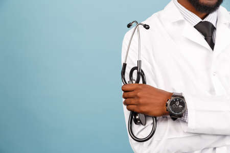 medicine, profession and healthcare concept. African American male doctor or scientist in white coat against blue backgroundの写真素材