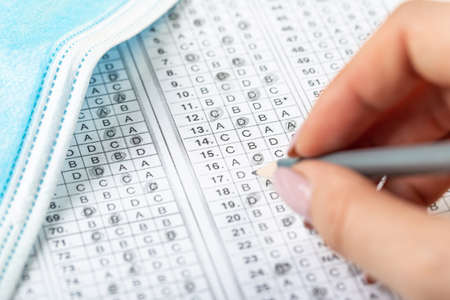 testing in exercise and examination work. computer worksheet with pencil in school test room, lead pencil and medical mask. the concept of education during a pandemicの写真素材