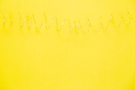 The garland is on. Glowing electric garland on a yellow background. top viewの写真素材